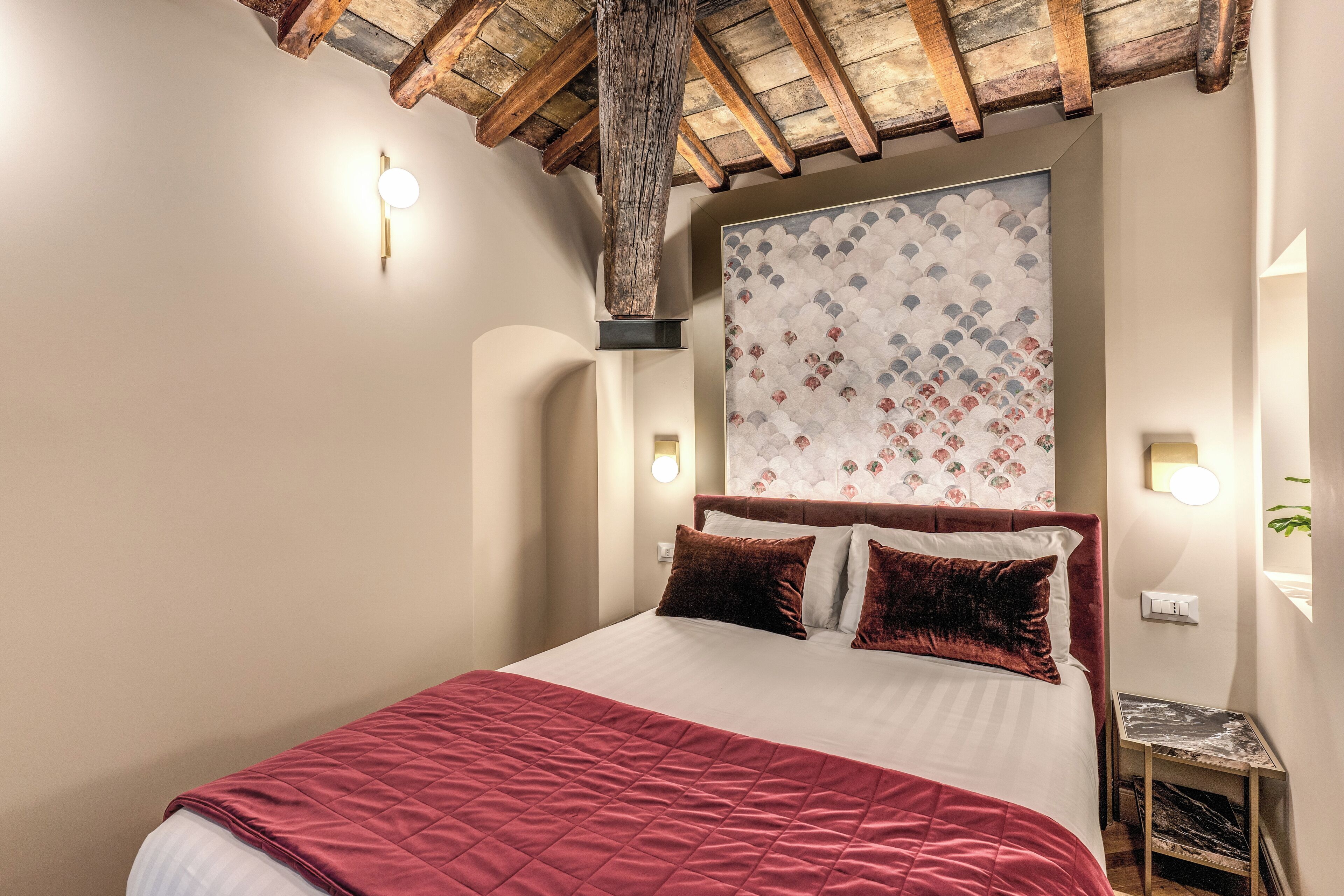 Une chambre à coucher avec un grand lit, un plafond en bois et un panneau décoratif au mur.