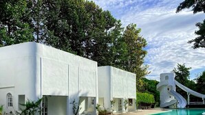 A swimming pool with a white building and a slide. - Villa La Flora Kaeng Krachan (Kaeng Krachan)