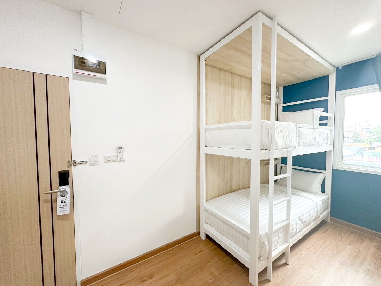 Une chambre avec un lit superposé, une armoire en bois et une fenêtre donnant sur un beau paysage.