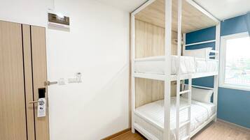 Une chambre avec un lit superposé, une armoire en bois et une fenêtre donnant sur un beau paysage.