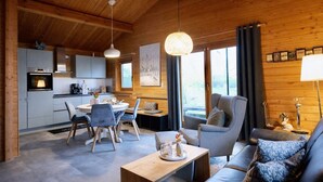 Un intérieur de chalet chaleureux comprenant un coin repas, une cuisine et un espace salon.