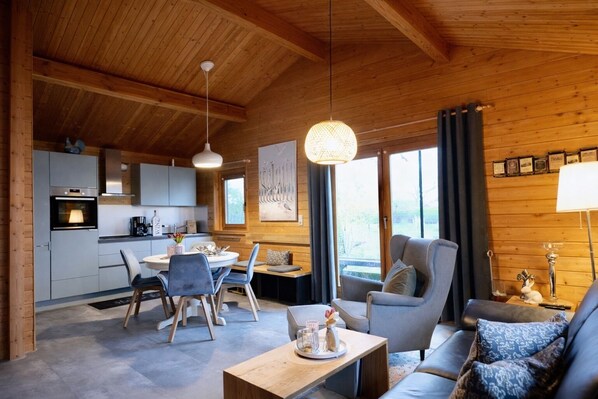 Un interior acogedor de cabaña con comedor, cocina y zona de estar.