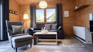 Une pièce confortable avec un canapé, un fauteuil et une table sur laquelle se trouve une lampe.