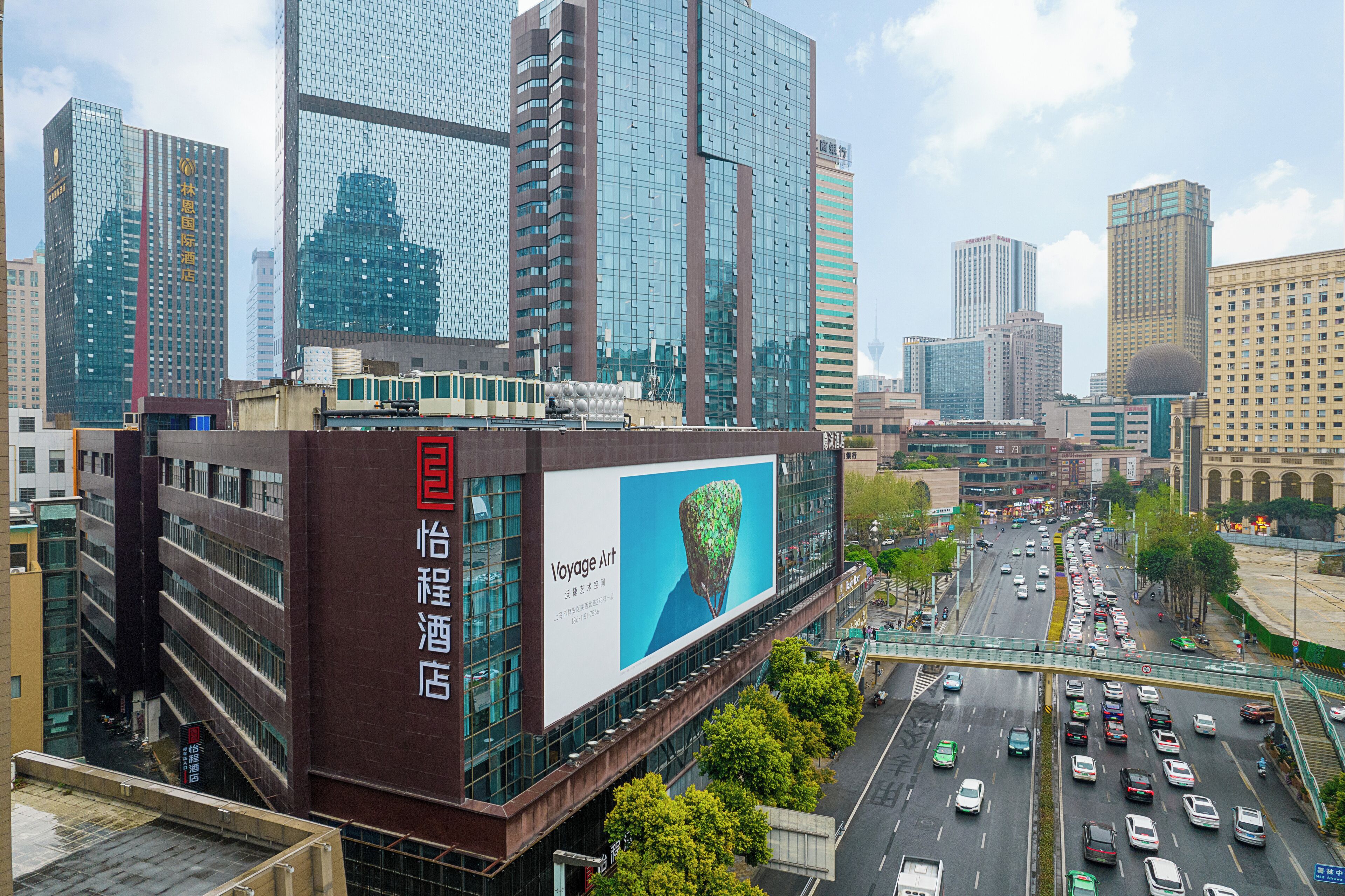 A modern hotel with a large billboard advertising a product.