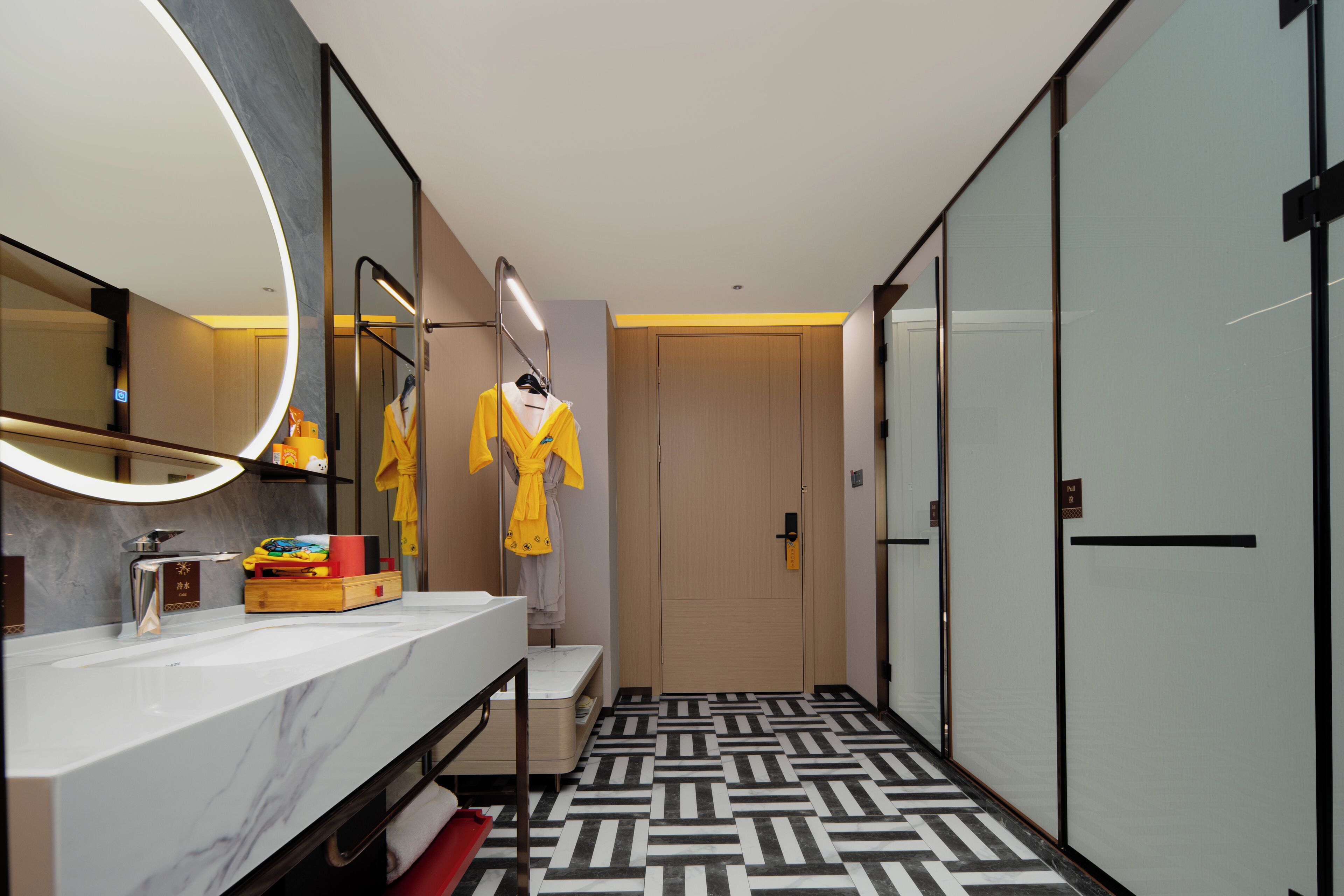 A modern bathroom with a marble sink, a large mirror, and a patterned floor.