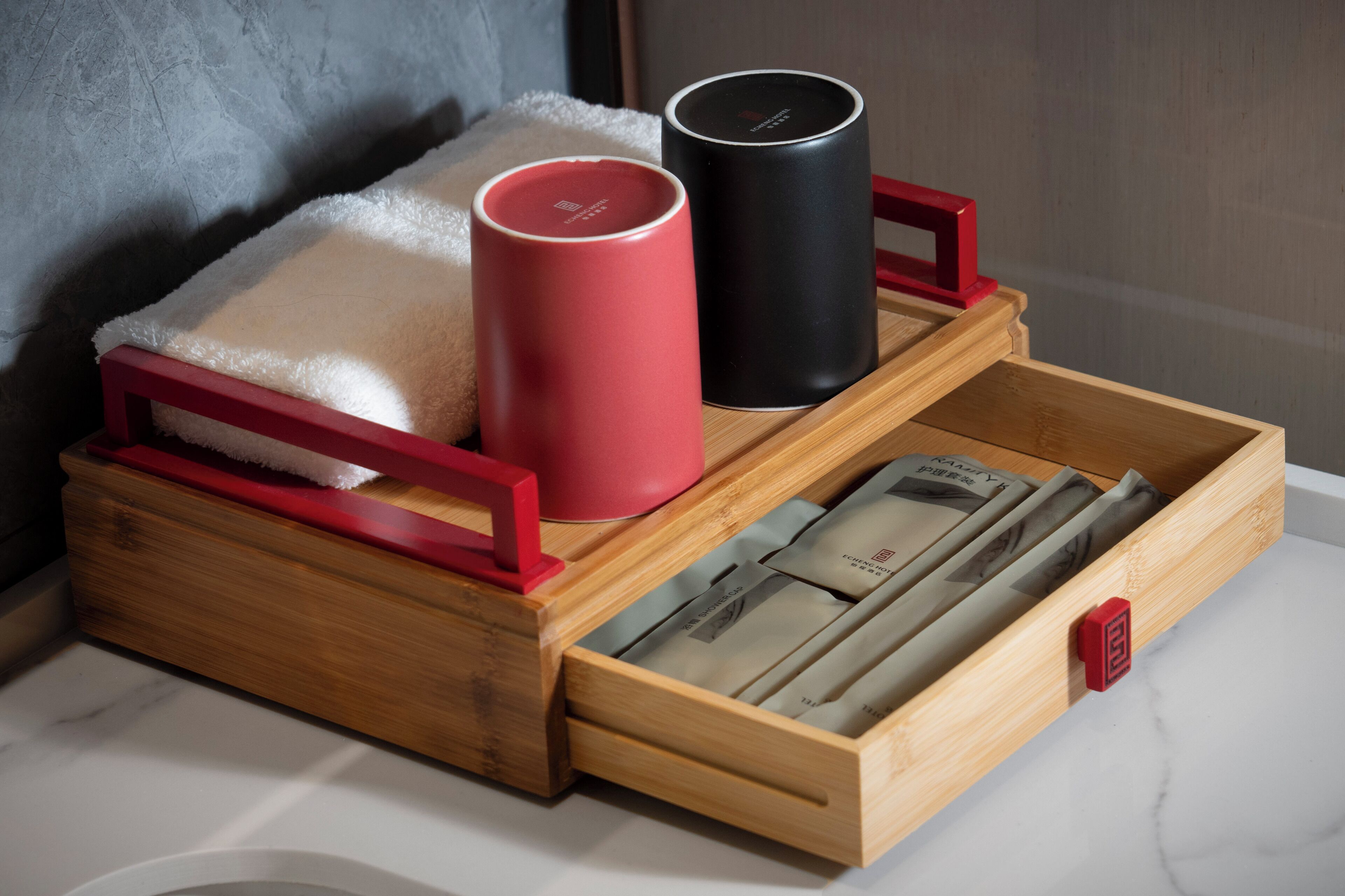 A wooden chest with a red handle, containing a red and a black cylindrical object, and a drawer with magazines.