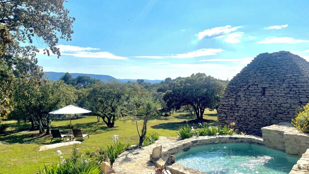 A pool area with stone walls, surrounded by lush greenery and a clear blue sky. - Le Mas Natán Au Coeur du luberon Gordes (Gordes)