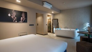 A modern hotel room with a large bed, a bathtub, and a mirror. - Bocca di Leone Luxury Suite (Rome)