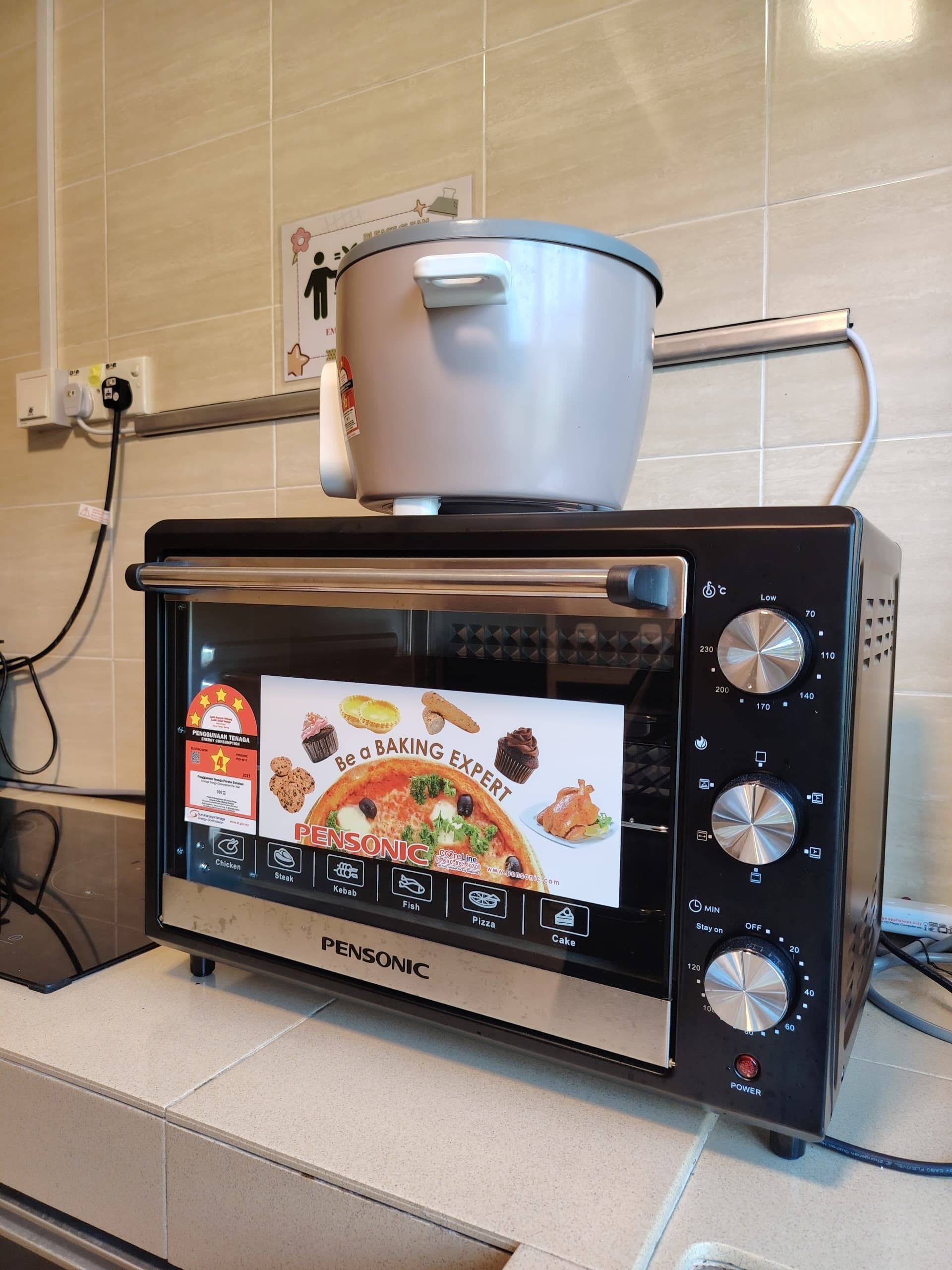 Un horno Pensonic con pantalla digital, una olla encima y un cable de alimentación conectado.