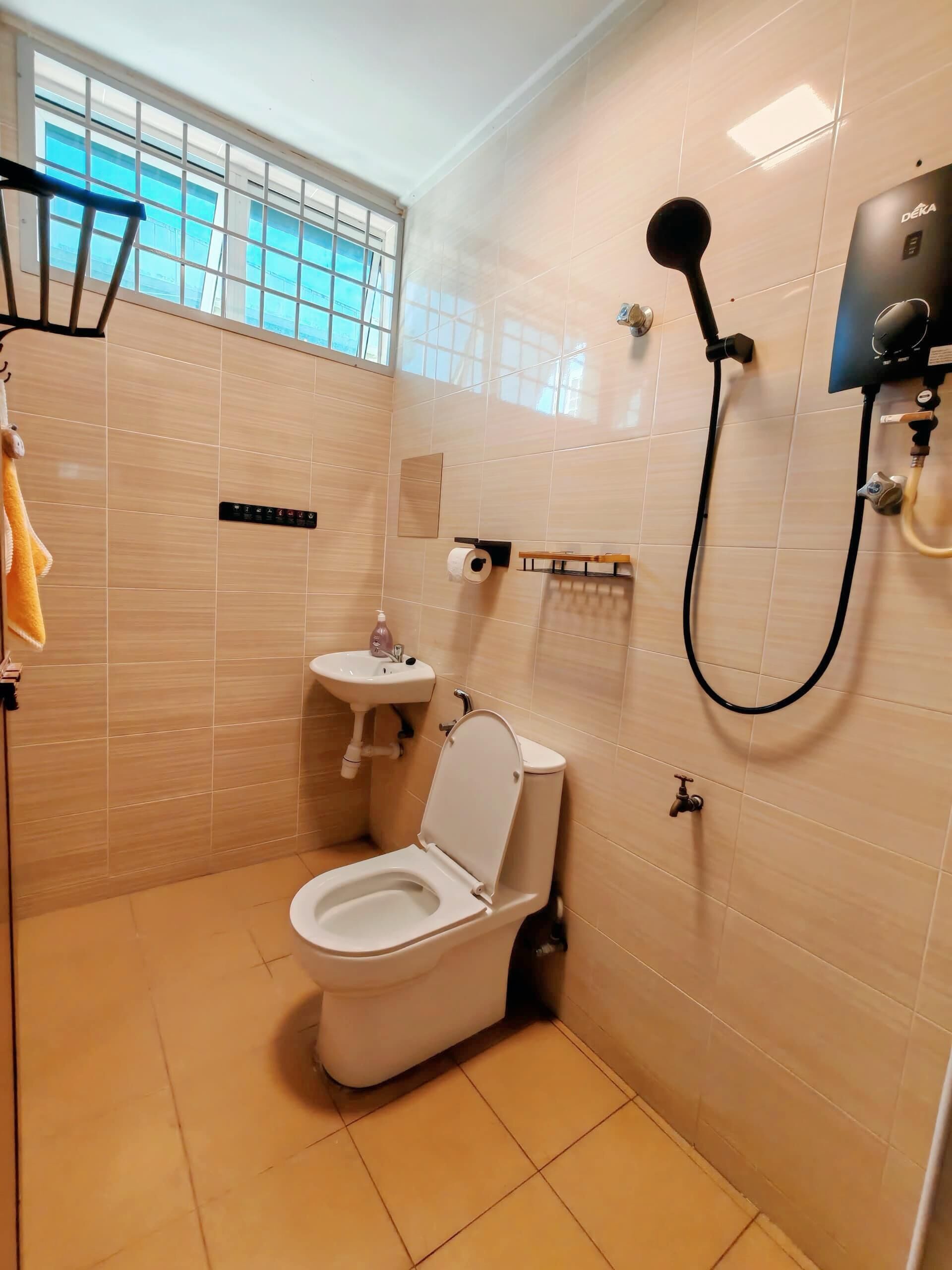 A modern bathroom with a toilet, sink, and shower.
