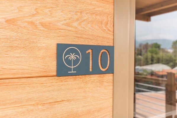 A wooden door with a number sign indicating room 10. - Domvs Glamp (Baveno)