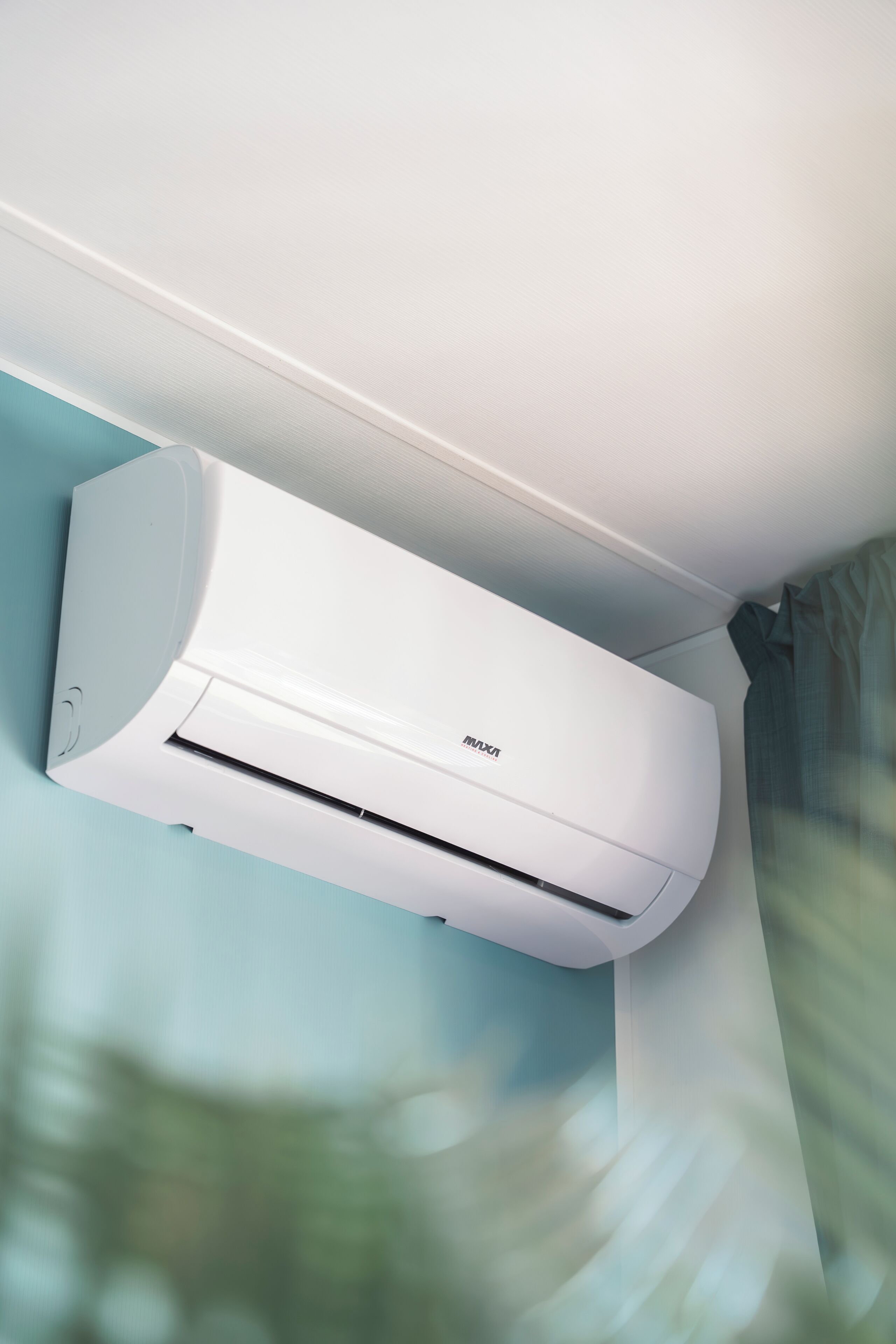 Een wit, aan de muur bevestigd airco-apparaat met een zichtbaar logo van het merk.