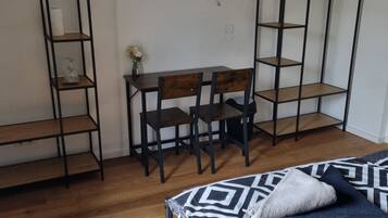 Une petite pièce comprenant un lit, un bureau et deux étagères.