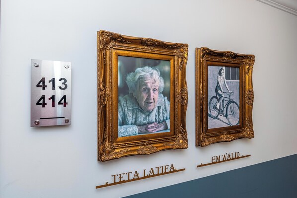 Two framed artworks on a wall with a metal plaque and a nameplate below them. - Mar Mikhael Studios (Beirut)