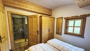 A bedroom with two beds, wooden wardrobes, a shower, and a window with a view. - Lovely apartment for 4 guests with WIFI, TV, pets allowed and panoramic view (Forstau)