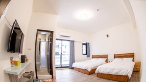 A hotel room with two beds, a TV, a desk with chairs, and a view of the outside. - BAOBAOB&B (Magong)