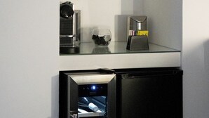 A compact kitchen with a built-in wine cooler, a coffee maker, and a glass container on the countertop. - Trullo delle Sfere, Luxury Trullo in the center of Alberobello (Alberobello)