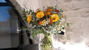 A modern room with a wooden desk, a vase of flowers, and a drawer with a red and white label. - Trullo delle Sfere, Luxury Trullo in the center of Alberobello (Alberobello)