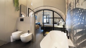 A modern bathroom with a freestanding bathtub, two toilets, and a large mirror. - Trullo delle Sfere, Luxury Trullo in the center of Alberobello (Alberobello)