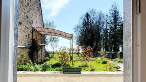 An open doorway to a courtyard with a gravel floor, a green planter, and a pergola structure. - TBM gîte country house completely renovated and quiet (Clamerey)