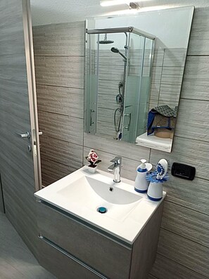 Een douche, een haardroger, een bidet, handdoeken