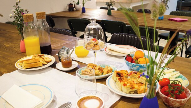 A dining table with various breakfast items, including bread, fruit, and a coffee cup. - Caramia srls (Crispiano)