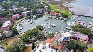Vue aérienne d’une marina où sont amarrés des bateaux, entourée de bâtiments et de verdure.