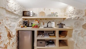 Una cocina compacta equipada con refrigerador, microondas, tostadora, pileta y diversos utensilios de cocina.