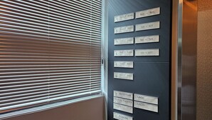 A wall with room and facility labels, including guest rooms numbered 4 to 9, a reception, private theater, toilet, lounge, and laundry. - Red hat snail (Seogwipo)