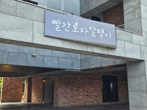 Un edifici amb un cartell en coreà, una paret de maó i una estructura de formigó.