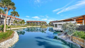 Et resort med pool, palmer og moderne bygninger.