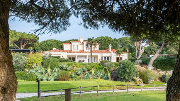 A large, two-story building with a red-tiled roof, surrounded by lush greenery and a well-maintained lawn. - Fairview Villa by Cadenzalux (Cascais)