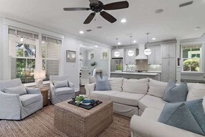 A modern living room with a sectional sofa, a coffee table, and a ceiling fan. - New Beginnings | Private Beach, Pool (Santa Rosa Beach)