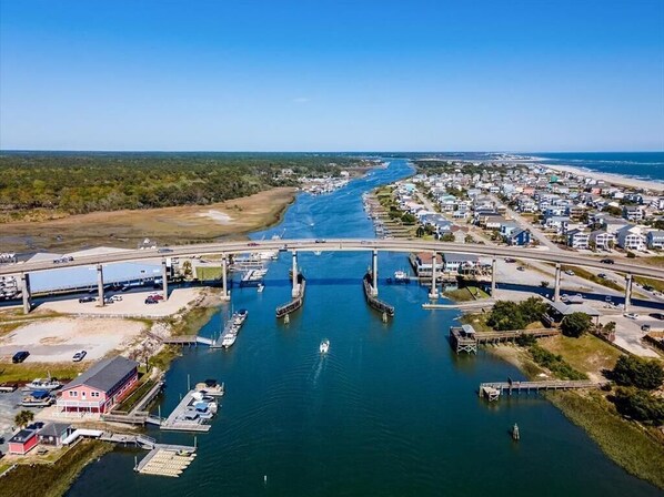 Vista aérea de un pueblo costero con un puente que une dos zonas sobre un río.