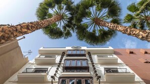 Un bâtiment à la façade symétrique, doté de nombreux balcons et d’une horloge située à l’étage supérieur.