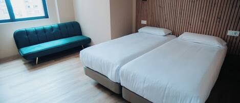 Un dormitorio moderno con un cabecero de listones de madera, una cama individual con ropa de cama blanca y un banco tapizado en color turquesa.