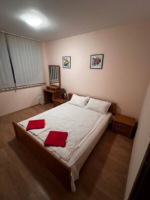Relax in this serene hotel room featuring a large bed, bedside table, and framed artworks.