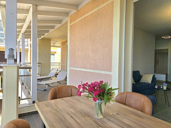 A modern hotel lobby with a wooden reception desk, a vase of flowers, and a seating area with sofas and chairs. - Hill Apartment with Sea View in Durres 061 (Durres)