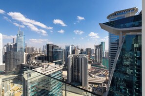 A high-rise building with a glass facade and a distinctive curved top. - SIMPLY COMFORT Missoni Top Floor with Sea, Canal and Burj Khalifa Views (Dubai)