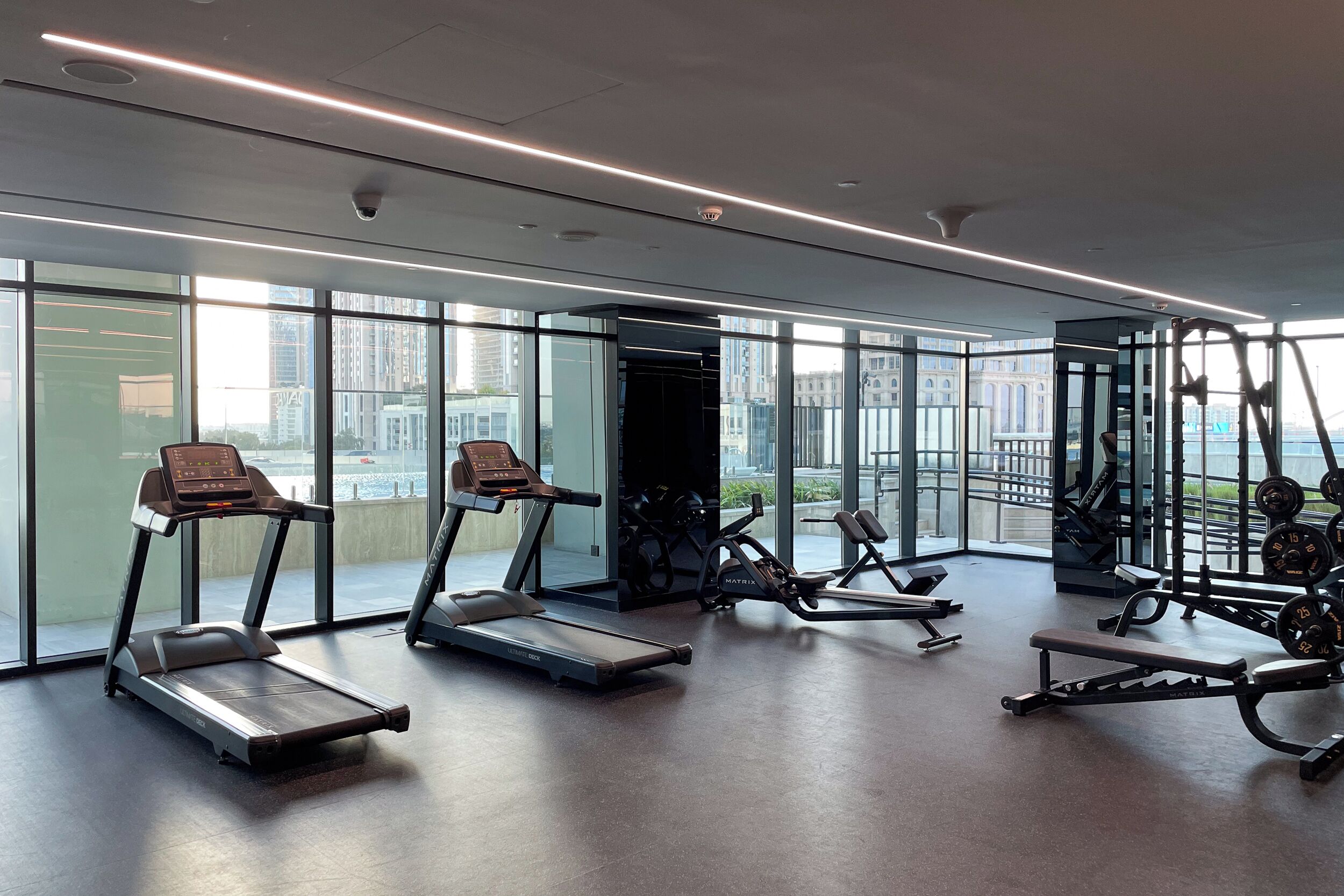 Ein modernes Fitnessstudio mit Laufbändern, Crosstrainern und Gewichtstrainern.