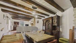 A dining area with a wooden table and chairs, a staircase, and a fireplace. - Lovely house with jacuzzi for 8 people (Mauzens-et-Miremont)