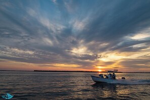 Ein Boot auf ruhigem Wasser bei Sonnenuntergang.