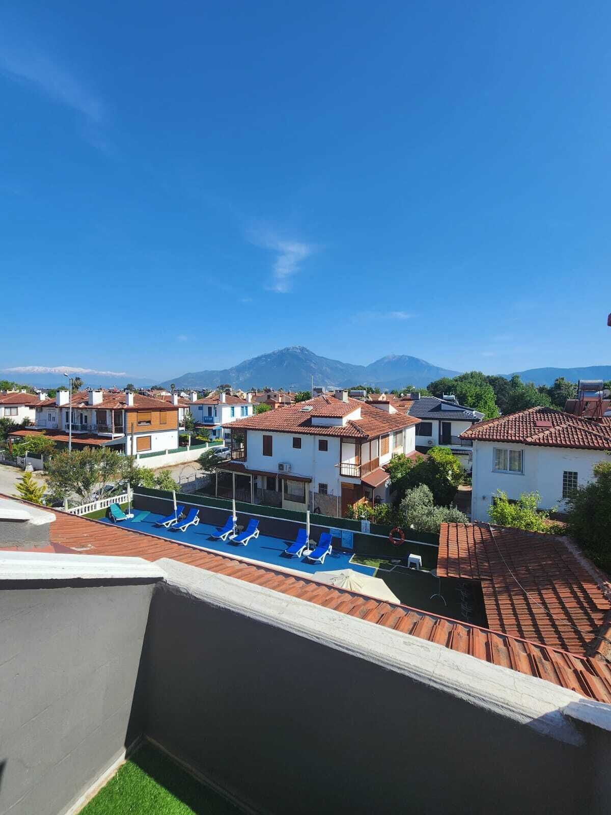Zona residencial amb piscina i una muntanya al fons.