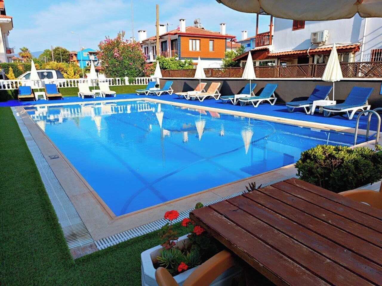 A swimming pool with lounge chairs and a wooden deck.