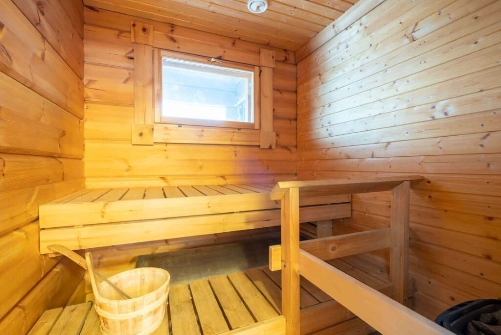 A wooden sauna room with benches and a window.
