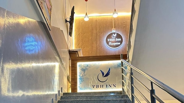 Un escalier menant à un espace d’accueil où se trouve une enseigne indiquant « VBH Inn ».