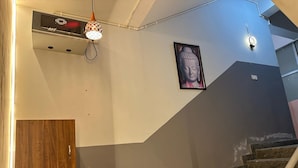 Un escalier avec une rampe en bois et un luminaire fixé au mur.