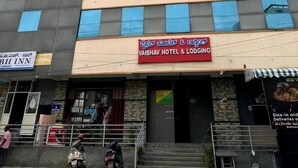 Un immeuble à plusieurs étages arborant des enseignes pour VBH Inn Deluxe Lodging et Vaibhav Hotel & Lodging.