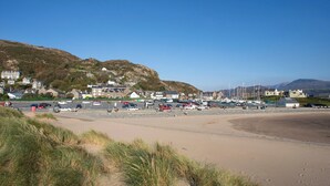 A coastal town with buildings, a sandy beach, and boats.