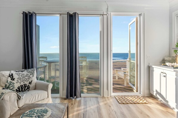 Una habitación con vistas a la playa, un sofá, una mesita de centro y un armario.